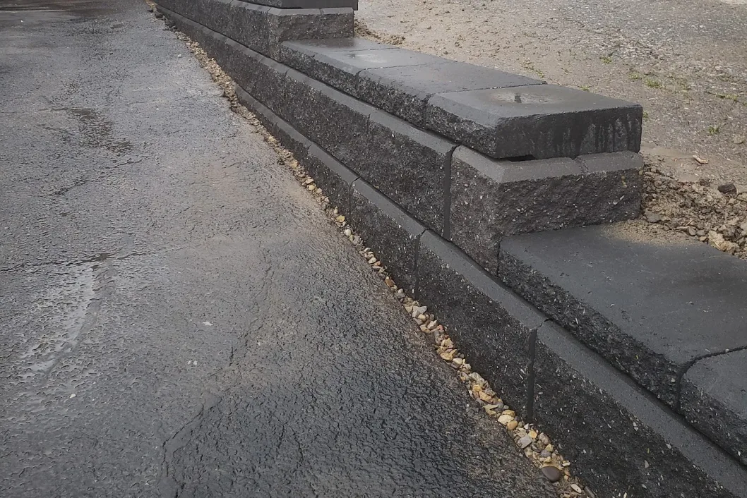 Charcoal stone curb edging against asphalt, Calgary hardscaping detail by All The Moore