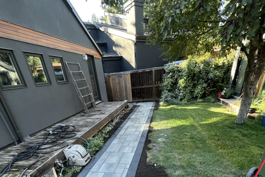 Side yard paver walkway path along cedar house exterior, Calgary