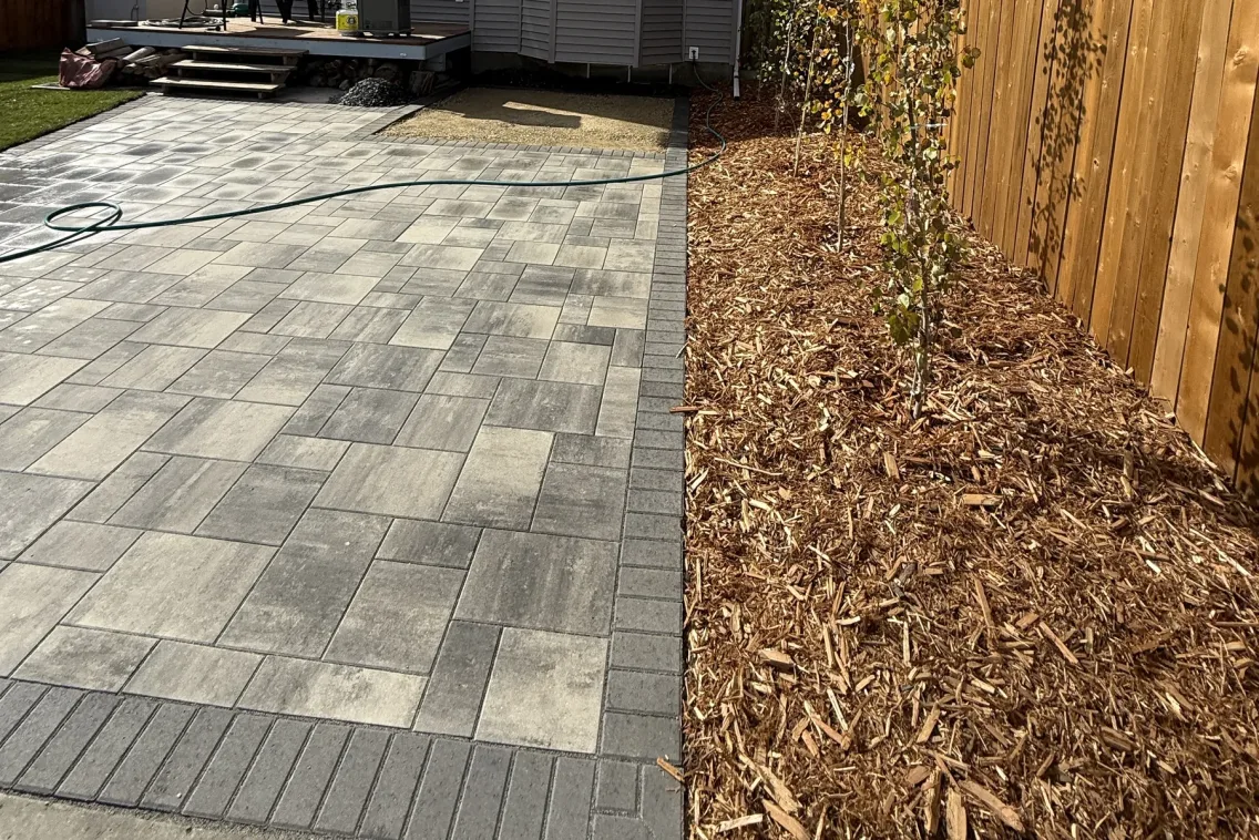 Clean paver patio and cedar fence showing professional property maintenance in Calgary