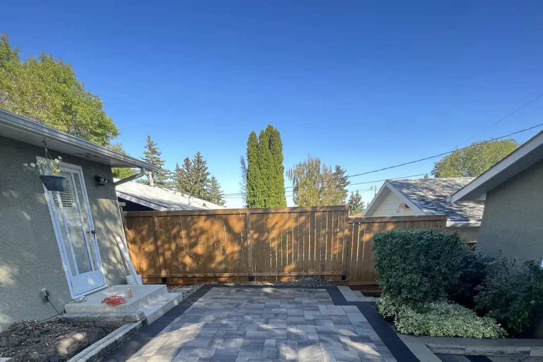 Paver patio with cedar fence backdrop and decorative pillars, Calgary backyard