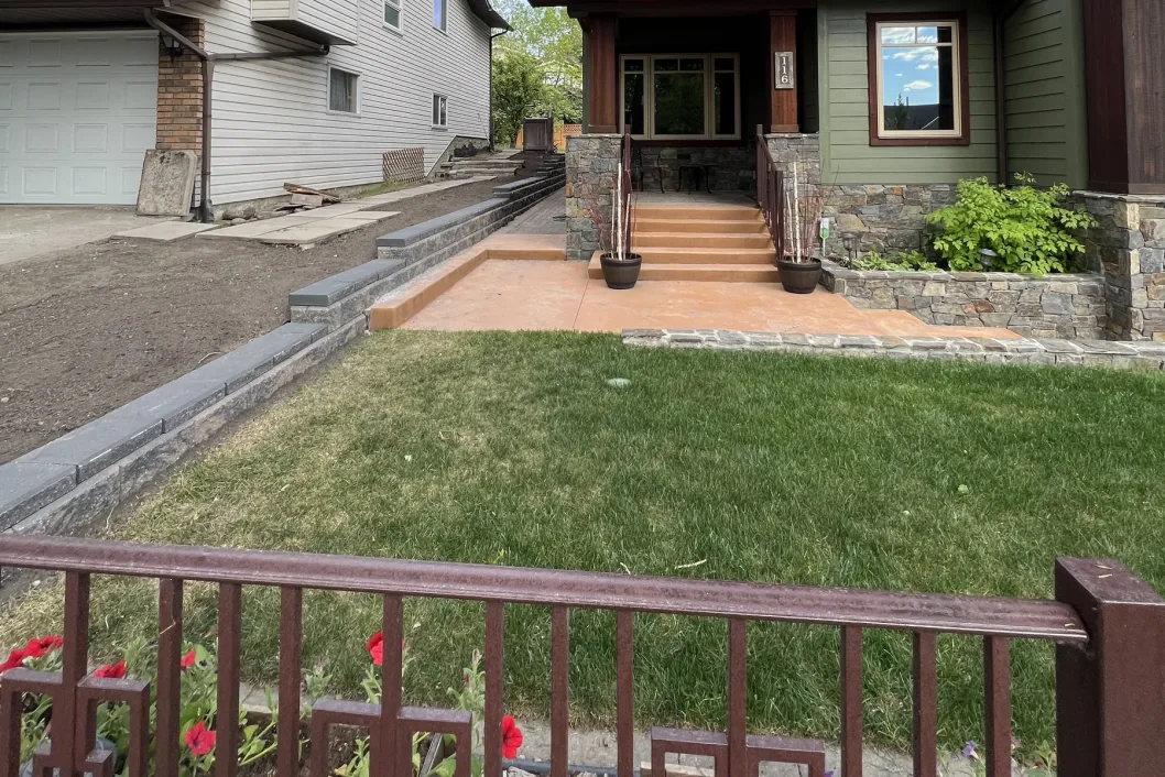 Front yard transformation with stamped concrete, stone retaining walls and dark block border accents, Calgary