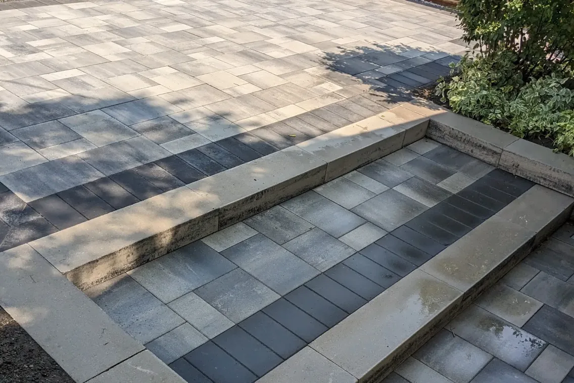 Two-tone paver patio with stone steps and slate cap detail, Calgary
