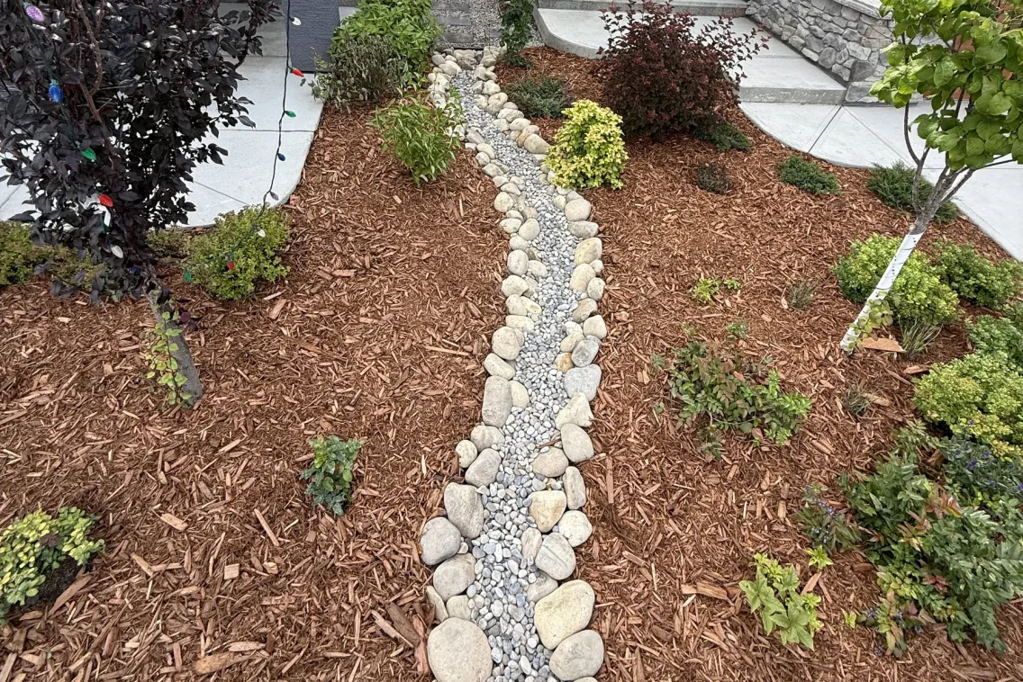 Path lights and river rock landscaping illuminated at night in Calgary